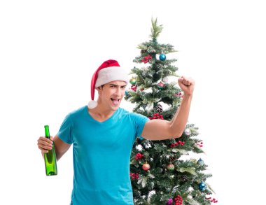Genç adam beyaz üzerine izole edilmiş noel ağacını süslüyor.