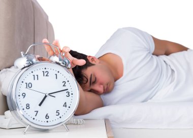 Yatakta uykusuzluk çeken bir adam.