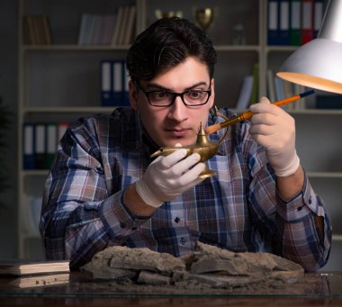 Arkeolog geç saatlere kadar ofiste çalışıyor.