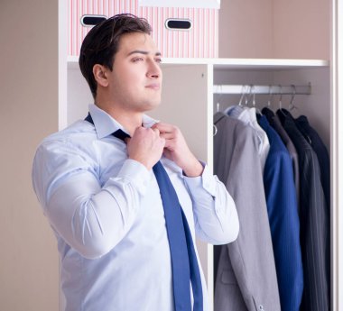 Genç işadamı iş için giyiniyor.