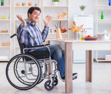 Engelli genç koca mutfakta çalışıyor.