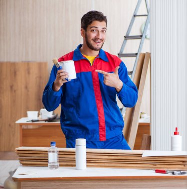 Yooung marangoz boyayla uğraşıyor.