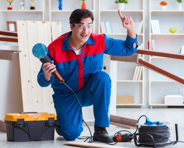 Genç marangoz ahşap kalaslarla çalışıyor.