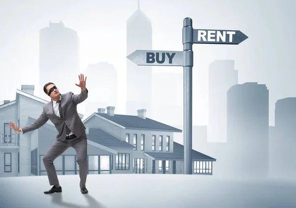 Businessman at crossroads betweem buying and renting — Stock Photo, Image