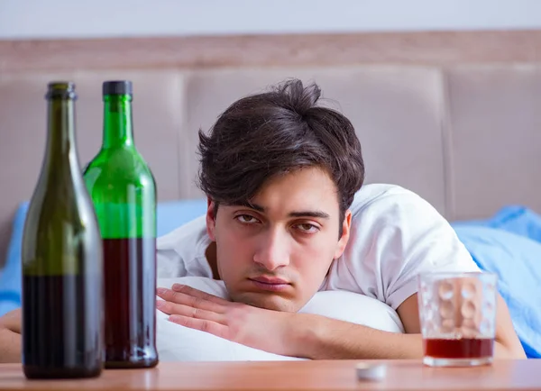 Hombre alcohólico bebiendo en la cama pasando por romper la depresión —  Fotos de Stock