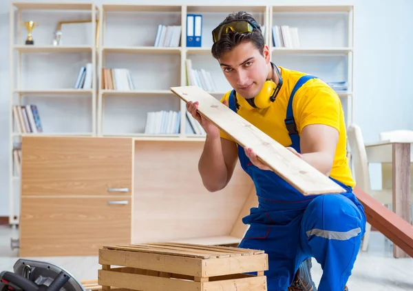 Reparador carpintero inspeccionando examinando una tabla de madera —  Fotos de Stock