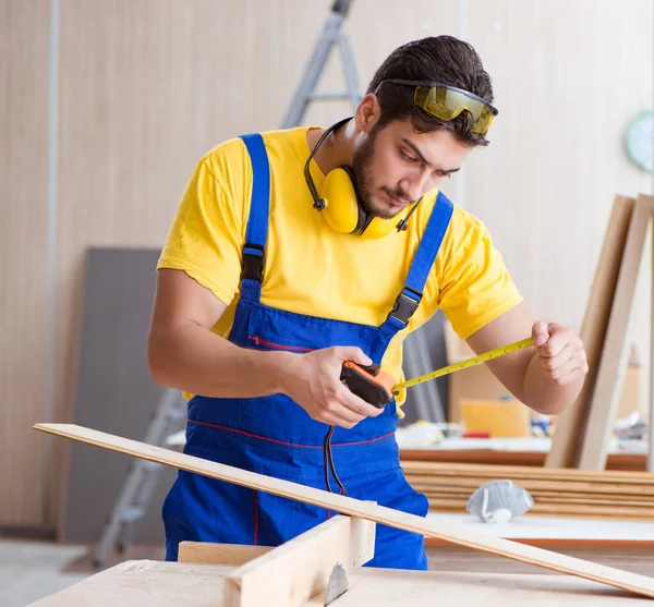 Jonge reparateur timmerman die hout snijdt op cirkelzaag — Stockfoto