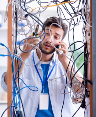 Elektrik teknisyeni tamir konseptinde kabloları çözmeye çalışıyor.