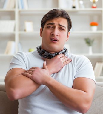 Genç adam boğaz ağrısı çekiyor.
