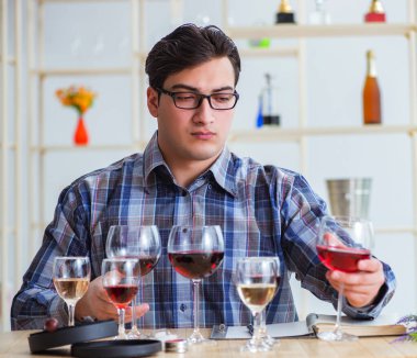Profesyonel şarap garsonu kırmızı şarap tadıyor.