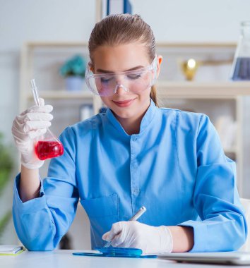 Bir laboratuarda deney yapan kadın bir bilim adamı.