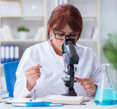 Bir laboratuarda deney yapan kadın bir bilim adamı.