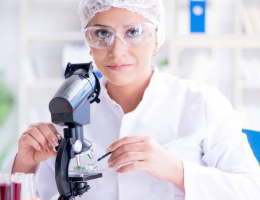 Bir laboratuarda deney yapan kadın bir bilim adamı.