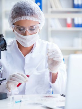 Bir laboratuarda deney yapan kadın bir bilim adamı.