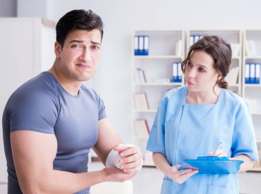 Hastanede yaralanma kontrolü sırasında doktor ve hasta.