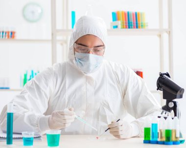 Laboratuvarda kimyasallar üzerinde çalışan genç bir kimyager.