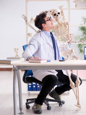 Çılgın profesör insan iskeleti üzerinde çalışıyor.