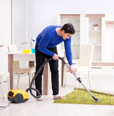 Genç adam evini temizliyor.