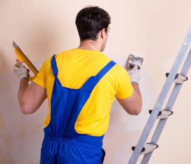 Duvara alçı yapıştıran genç müteahhit.