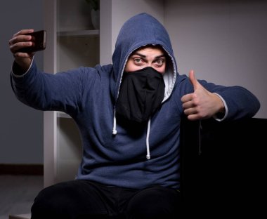 Hırsız, apartmandan televizyon çalıyor.