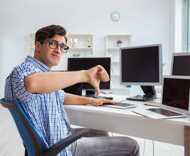 Birçok ekranın önünde oturan bir iş adamı