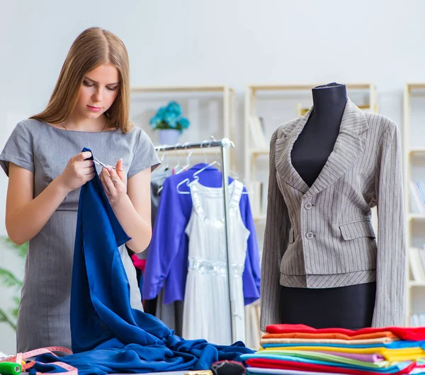 Mujer joven sastre trabajando en taller sobre vestido nuevo — Foto de Stock