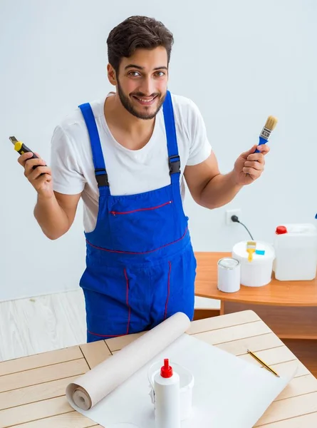 Werknemer werkt aan behang tijdens renovatie — Stockfoto