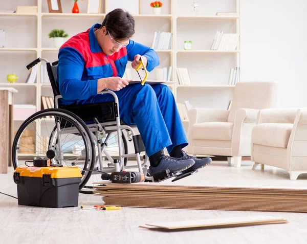 Hombre discapacitado que pone piso laminado en la oficina —  Fotos de Stock