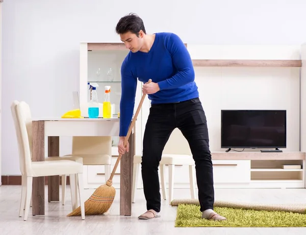 Fiatal férfi takarítás padló seprűvel — Stock Fotó