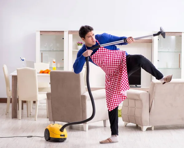 Young man vacuum cleaning his apartment — Stock Photo, Image