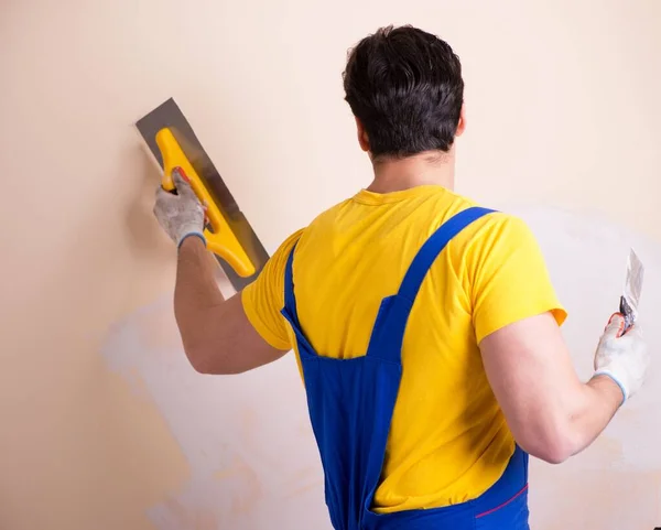 Empleado joven contratista aplicando yeso en la pared —  Fotos de Stock