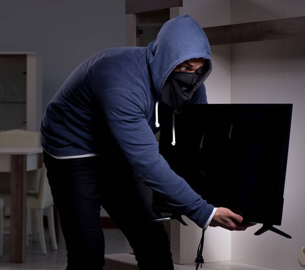 Burglar thief stealing tv from apartment house