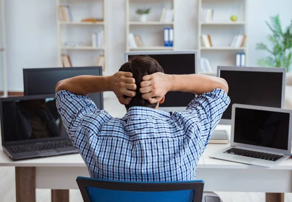 Zakenman zit voor veel schermen — Stockfoto