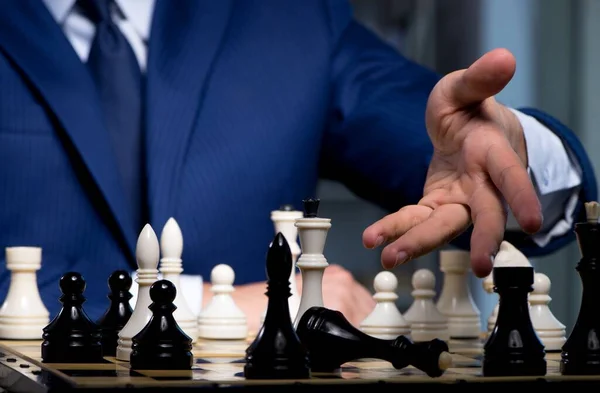 Businessman playing chess in strategy concept — Stock Photo, Image