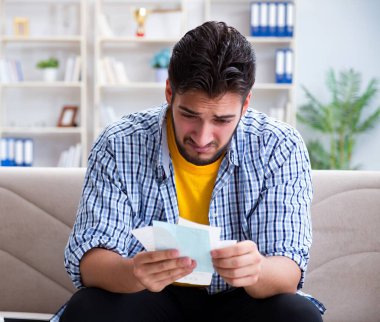 Ödeme yapması gereken faturalara kızgın bir adam.