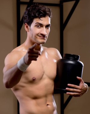 Spor salonunda besin takviyesi olan bir adam.