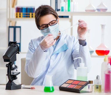 Laboratuar kimyageri güzellik ve makyaj ürünlerini kontrol ediyor.