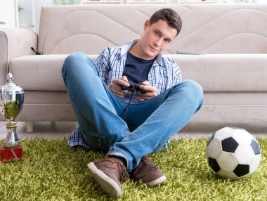 Genç adam evde bilgisayar oyunu oynuyor.