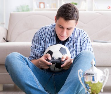 Genç adam evde bilgisayar oyunu oynuyor.