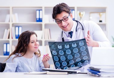 Doktor hastanın röntgen sonuçlarına açıklama yapıyor.