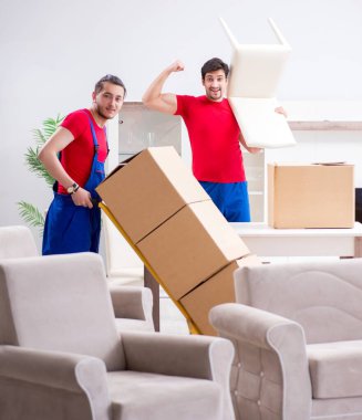 İki müteahhit personel kişisel eşyalarını taşıyor.