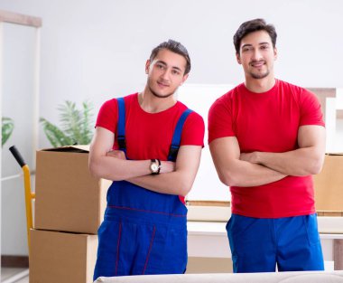 İki müteahhit personel kişisel eşyalarını taşıyor.