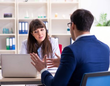 İş adamı doktorla sağlık sorunlarını tartışıyor