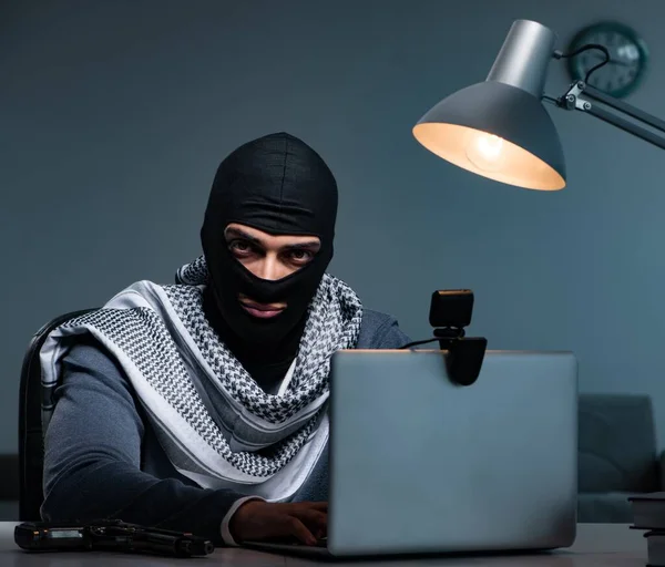 Hacker wearing balaclava mask hacking computer