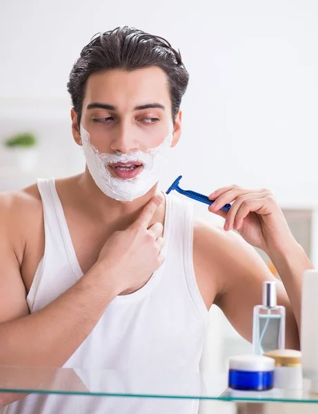 Fiatal jóképű férfi borotválkozik korán reggel otthon. — Stock Fotó