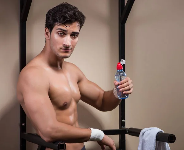 Hombre sediento bebiendo agua en el gimnasio deportivo — Foto de Stock