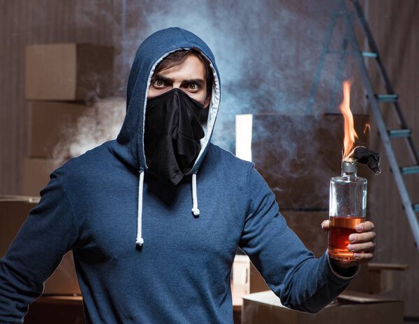 Мятежник с коктейлем Молотова в темной комнате