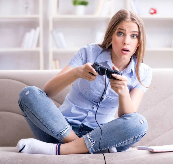 Jonge vrouwelijke student speelt spelletjes thuis — Stockfoto