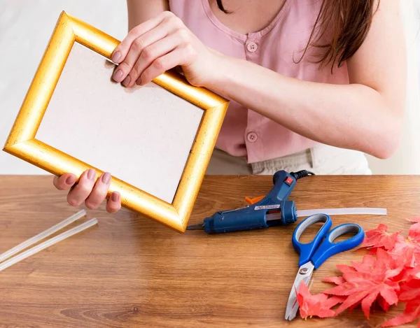 Woman decorating picture frame in scrapbooking concept — Stock Photo, Image