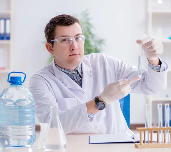 Jeune étudiant chimiste expérimentant en laboratoire — Photo